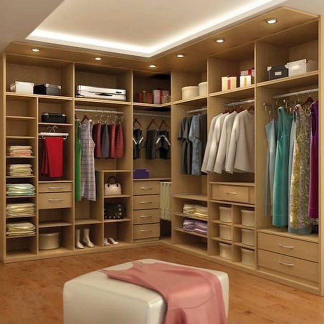 Організація зберігання речей в спальні за допомогою кутової шафи з дзеркальними дверцятами.