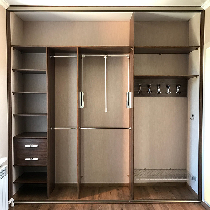 Кутова шафа з полицями та штангами для зручного розміщення одягу та аксесуарів в спальні.