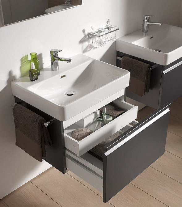 Оздоблення ванної кімнати: тумба під раковину з темного дерева та світла плитка.