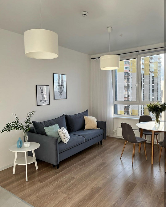 Стильний диван на ніжках в світлому інтер'єрі, дизайн вітальні 2024