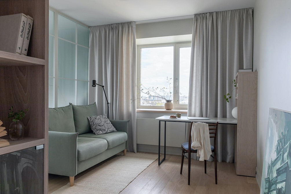 Двомісний диван на високих ніжках з подушками різних кольорів.