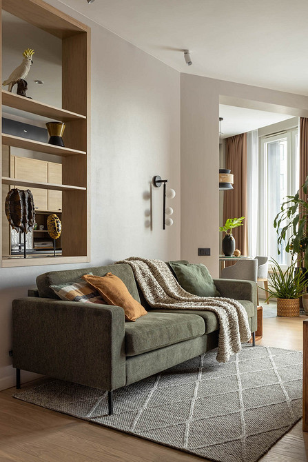 Сучасний диван на ніжках у вітальні з килимом та декором.