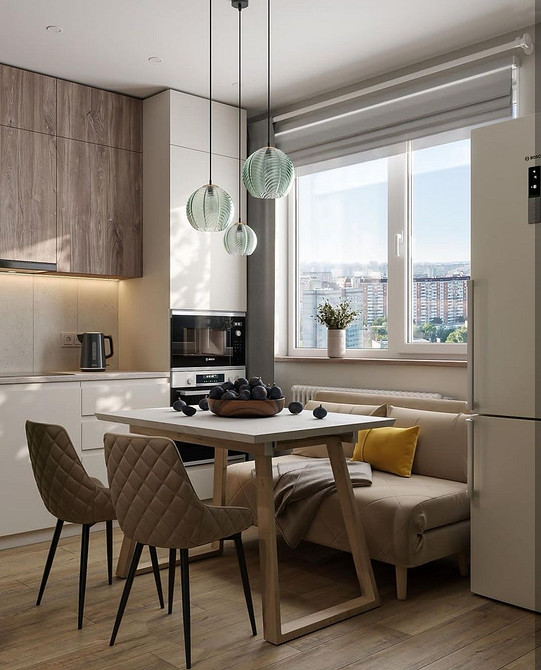 М'який диван на ніжках з подушками у вітальні з паркетом і журнальним столиком.