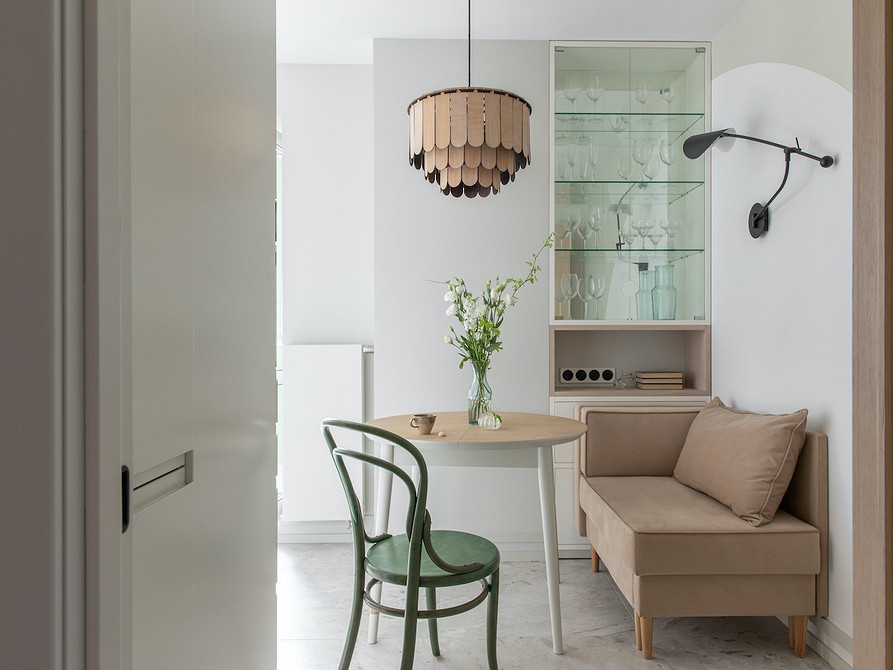 Диван на низьких ніжках з однотонною оббивкою в мінімалістичному інтер'єрі.