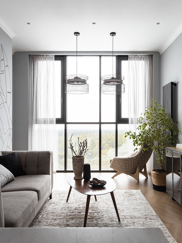 Двомісний диван на ніжках в невеликій вітальні, сучасний дизайн інтер'єру