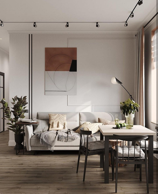 Кутовий диван на металевих ніжках в просторій вітальні з панорамними вікнами.