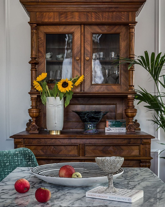 Сервант з темного дерева для посуду в вітальні з каміном