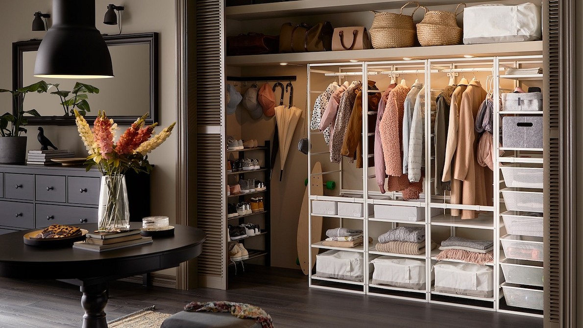 Сучасна шафа в передпокій з дерев'яними фасадами та чорними металевими ручками.