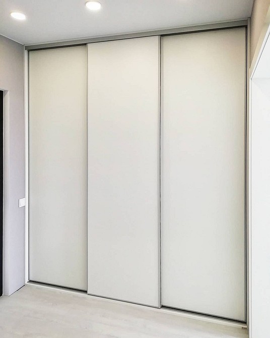 Мінімалістична шафа для прихожої з гладкими фасадами без зайвих деталей.