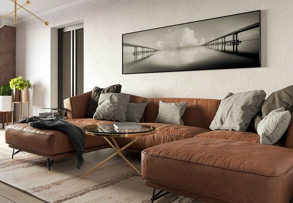 Просторий коричневий кутовий диван у вітальні з килимом та журнальним столиком.