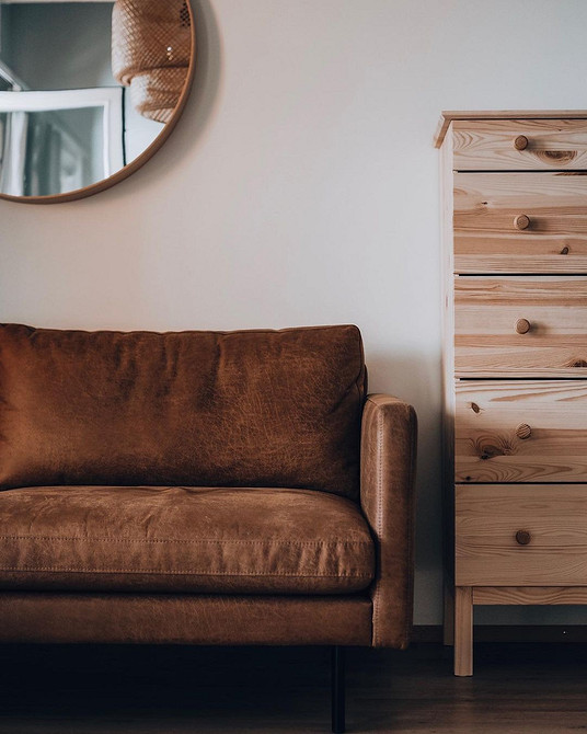 Розкішний коричневий диван честерфілд у класичному інтер'єрі з каміном.