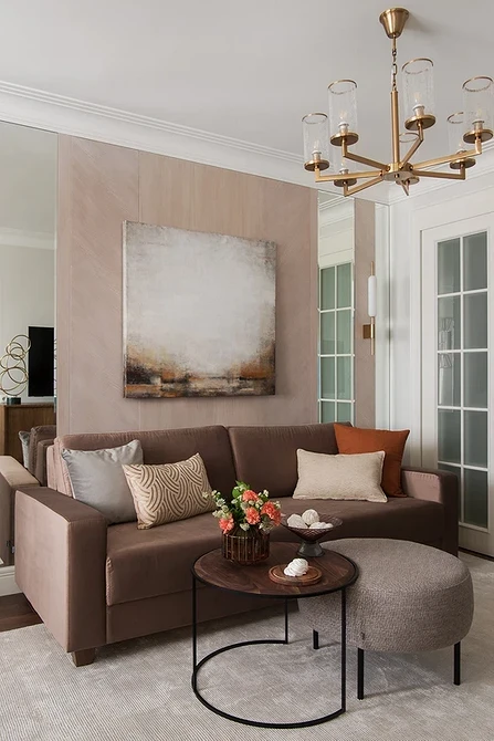 М'який велюровий коричневий диван з декоративними подушками в інтер'єрі