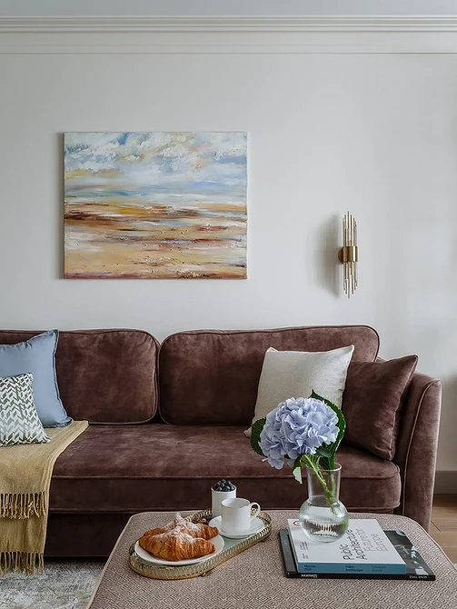 Затишний кутовий коричневий диван у вітальні з килимом та журнальним столиком