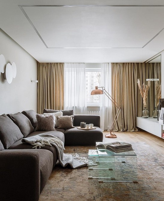 Коричневий велюровий диван з декоративними подушками в інтер'єрі вітальні