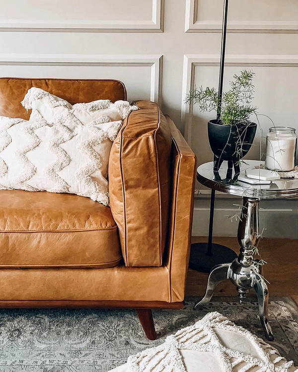 Сучасний шкіряний диван у світлій вітальні. Меблі з натуральної шкіри та стильний дизайн.