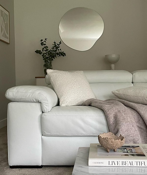 Маленький шкіряний диван в невеликій вітальні з дерев'яною підлогою