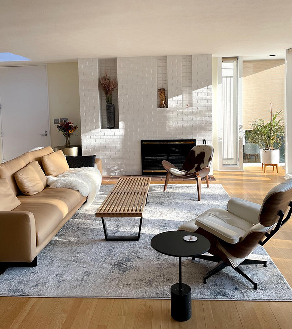 Шкіряний кутовий диван темного кольору в просторій вітальні, ідеальний колір дивану.