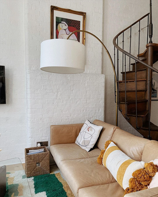 Елегантний шкіряний диван бежевого кольору в класичному інтер'єрі вітальні.