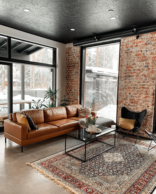 Бежевий шкіряний диван в світлому інтер'єрі, спокійний та затишний дизайн вітальні.