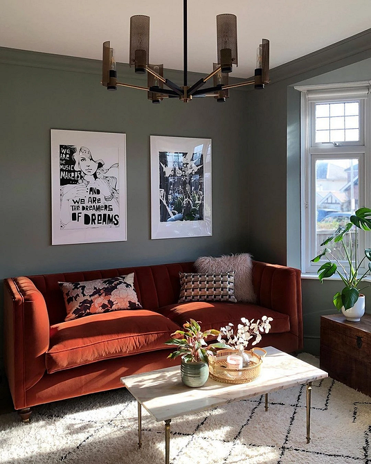 Інтер'єр вітальні з акцентним червоним диваном та килимом в тон