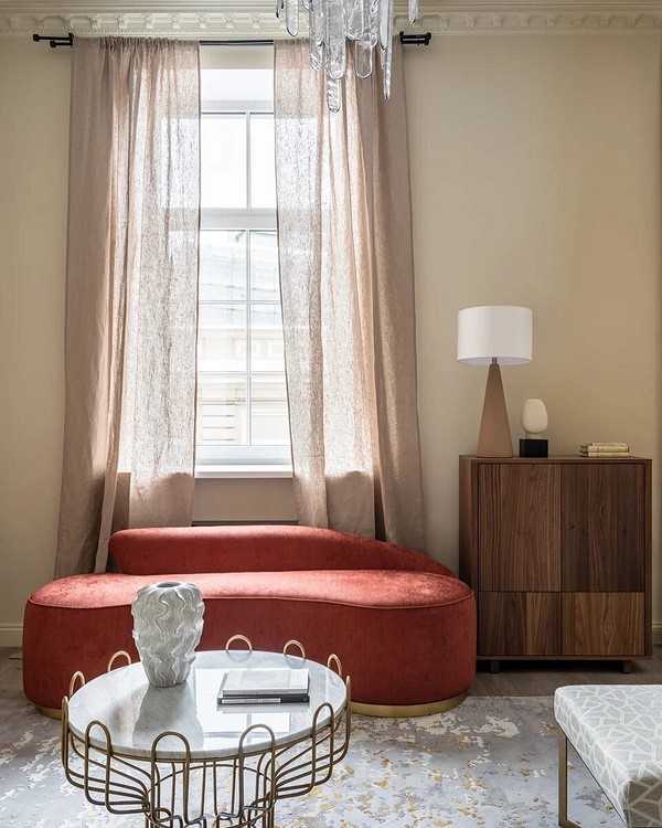 Червоний диван в інтер'єрі з бежевими стінами та дерев'яною підлогою, поєднання кольорів