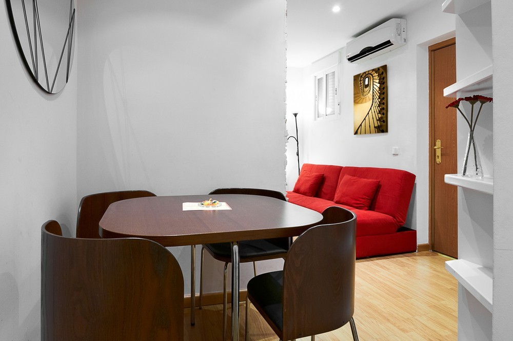 Розкішний червоний диван з велюровою оббивкою у вишуканому інтер'єрі вітальні