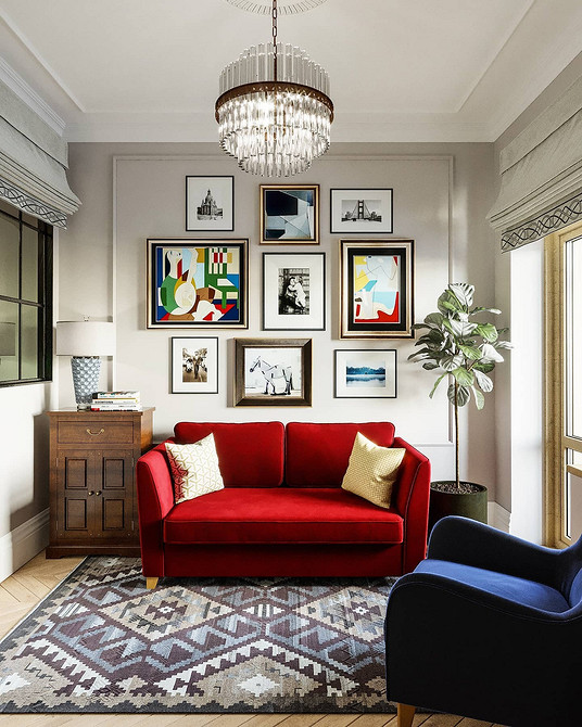 Яскравий червоний диван у вітальні з білими стінами та кольоровими акцентами в декорі