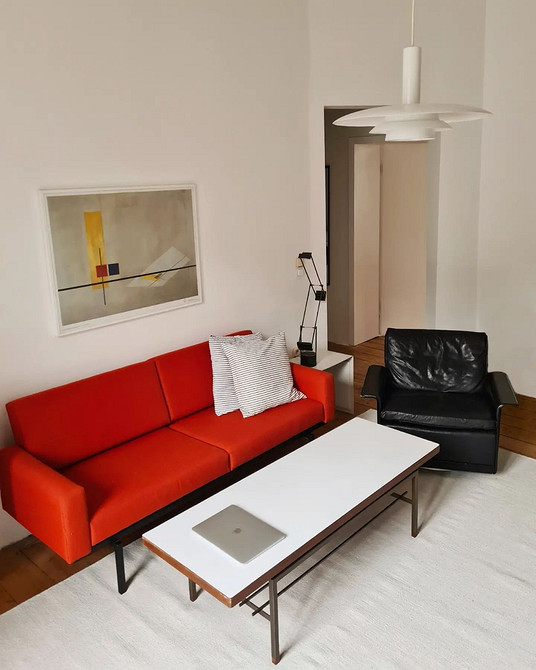 Елегантний червоний диван в інтер'єрі: поєднання з білими стінами та золотистими деталями