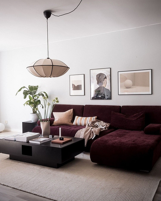 Сучасний дизайн вітальні з червоним диваном та декоративними подушками