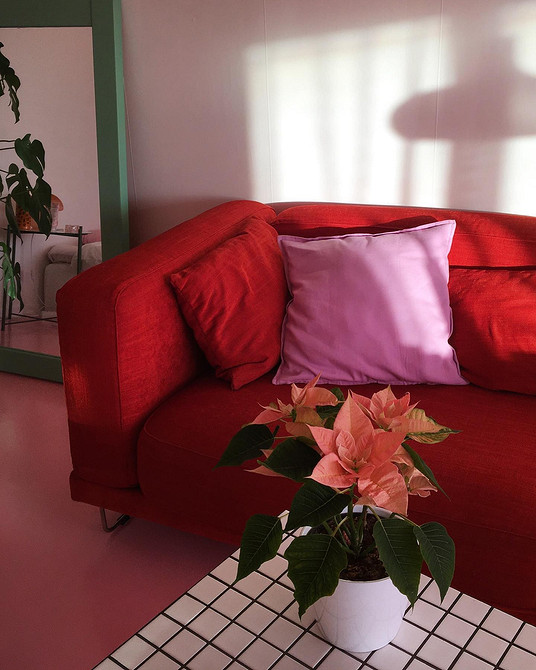 Велика вітальня з панорамними вікнами та червоним кутовим диваном, сучасний дизайн.