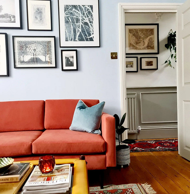 Червоний диван в інтер'єрі вітальні: поєднання з сірими стінами та дерев'яним столиком