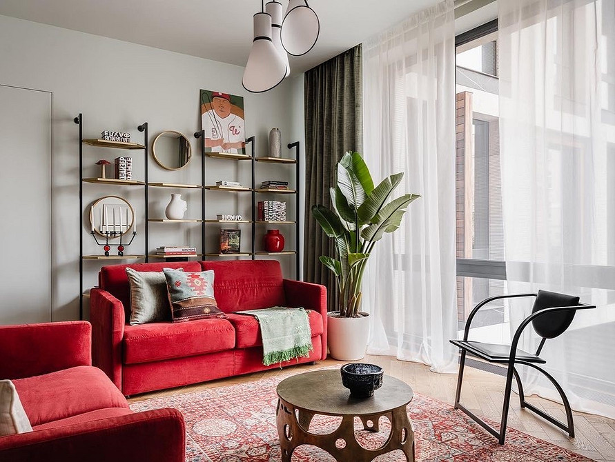 Дизайн вітальні з червоним диваном та каміном, класичний інтер'єр з акцентом.