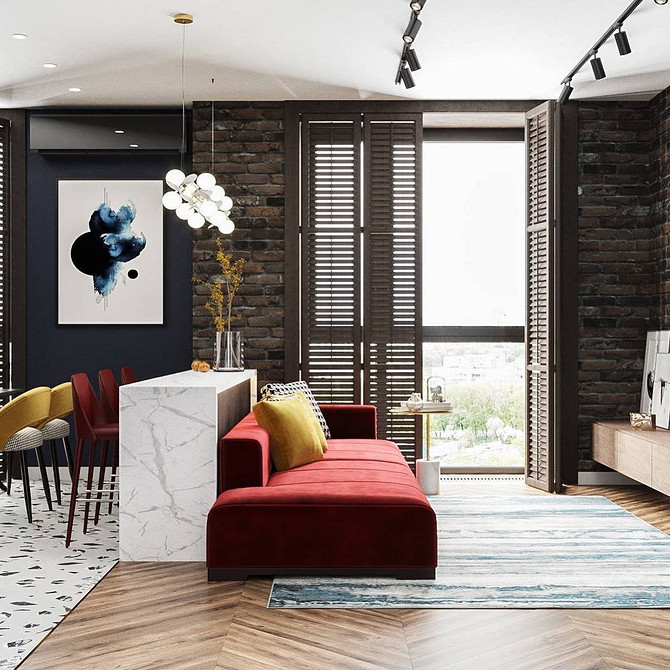 Невеликий червоний диван у вітальні з рослинами та книжковими полицями в стилі бохо