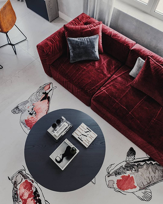 Дизайн вітальні з великим кутовим червоним диваном та журнальним столиком
