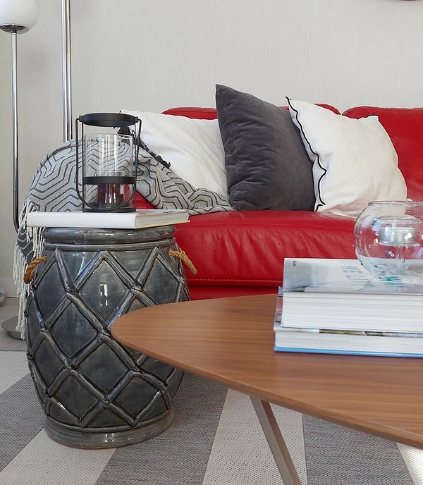 Маленький червоний диван у мінімалістичному інтер'єрі вітальні