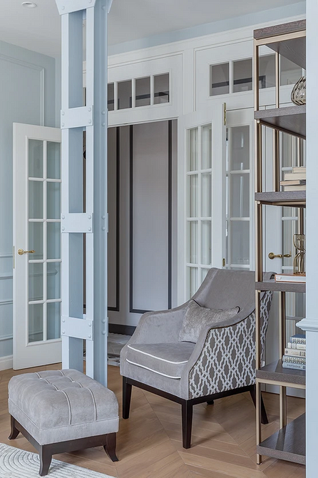 М'яке крісло з подушками в світлій вітальні, комфорт та стиль.