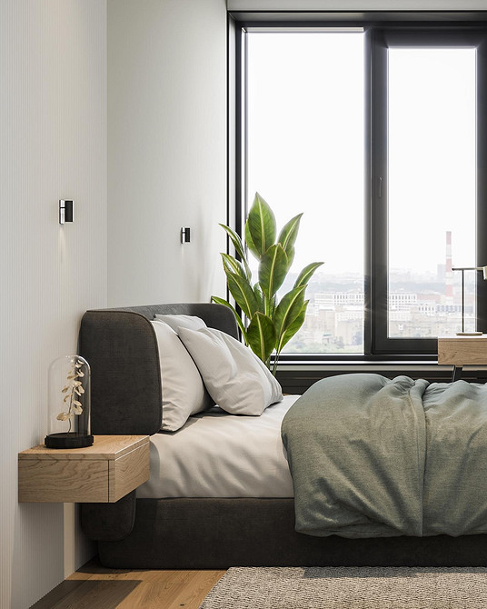 Інтер'єр спальні з акцентним ліжком з м'яким узголів'ям та декоративними подушками.