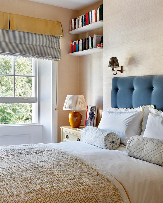 Затишна спальня з ліжком з високою м'якою спинкою, що забезпечує комфорт та підтримку.