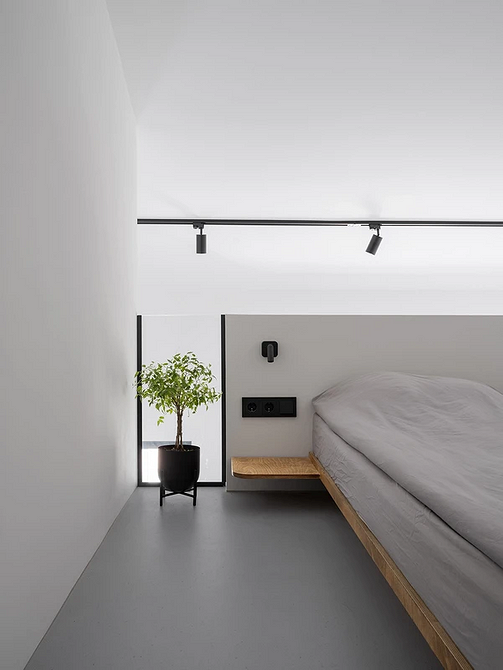 Тренди ліжок 2025: сучасне ліжко з м'яким узголів'ям в мінімалістичній спальні.