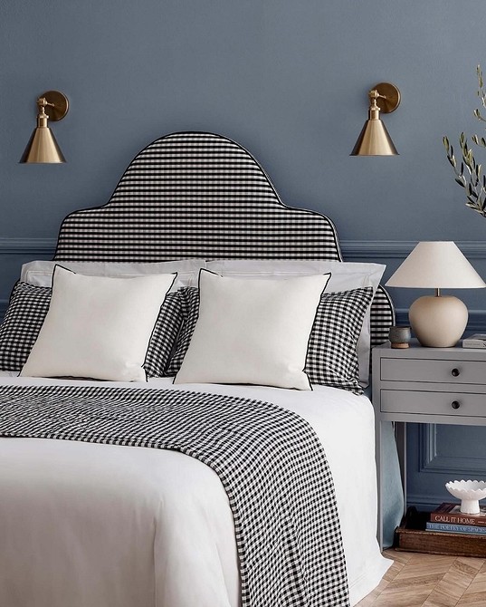 Велике м'яке узголів'я ліжка, що займає всю стіну, для максимального комфорту.