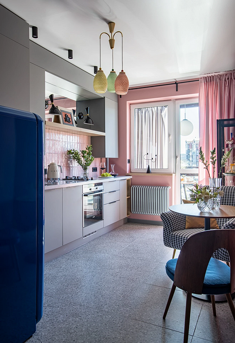 Обідня зона з круглим столом та оригінальним освітленням в сучасному дизайні кухні.