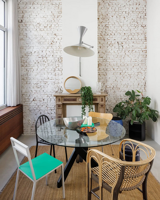 Сучасний скляний круглий стіл в обідній зоні, що підкреслює мінімалістичний дизайн кухні.