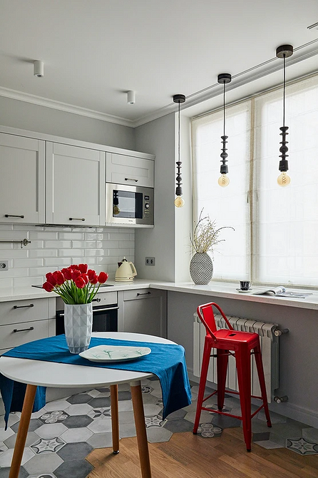 Круглий стіл в центрі кухні, оточений зручними стільцями, створює комфортну обідню зону.