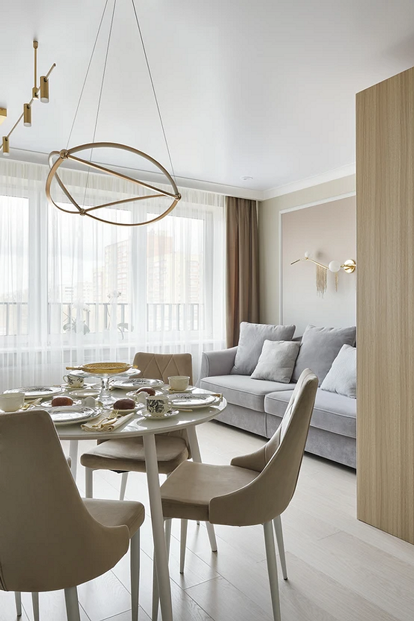 Круглий обідній стіл у вітальні: затишна обідня зона біля вікна.