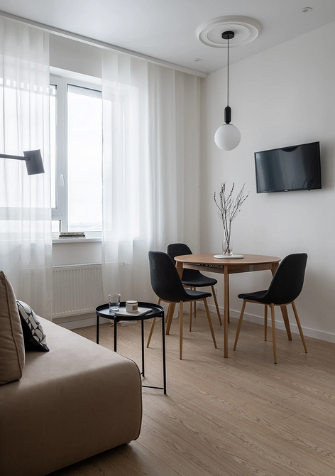 Сучасний дизайн вітальні з круглим столом та акцентними деталями.