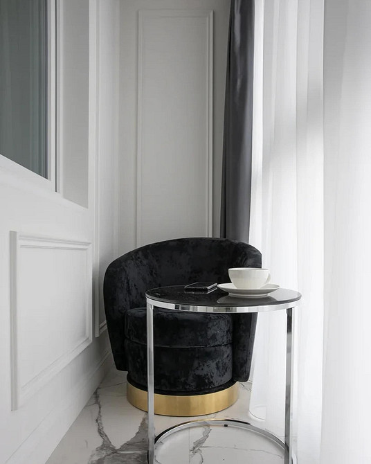 Круглий обідній стіл у вітальні з м'якими стільцями та сучасним освітленням, комфорт