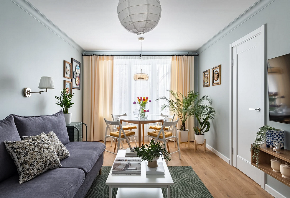 Меблі для вітальні: круглий дерев'яний стіл та зручні стільці.