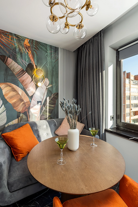 Стильний пластиковий круглий стіл на кухні з яскравими акцентами декору.