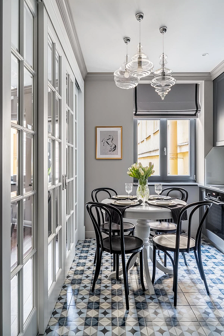 Мінімалістичний дизайн кухні з білим круглим столом та лаконічними стільцями.