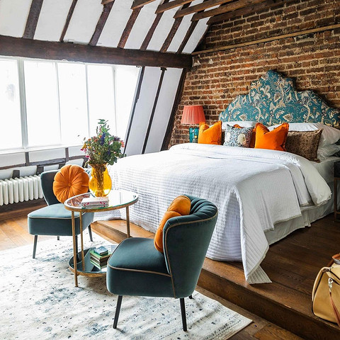 Інтер'єр спальні з ліжком з металевим узголів'ям в стилі мінімалізм та приліжковими тумбочками.